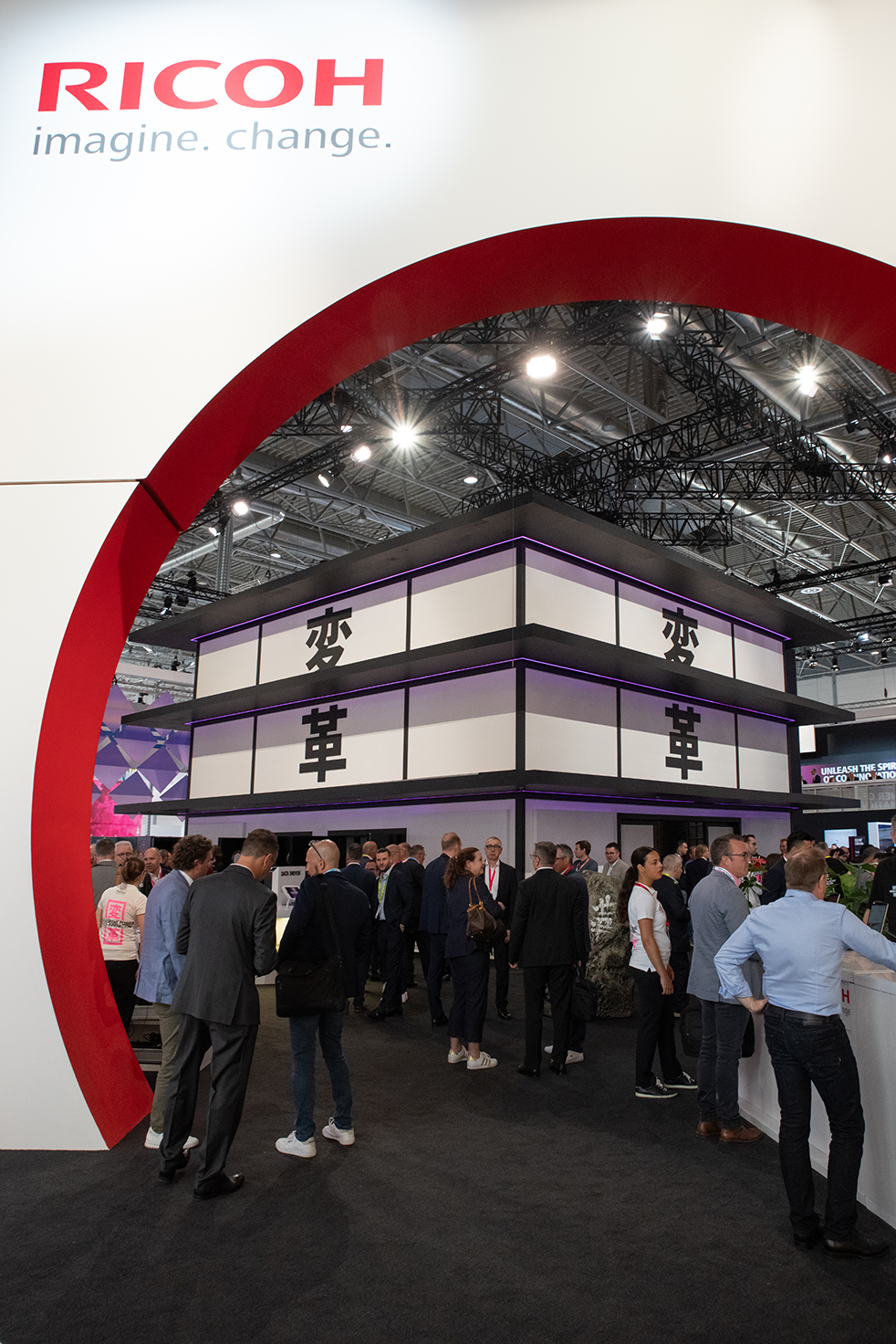 A group of people standing under Ricoh arch